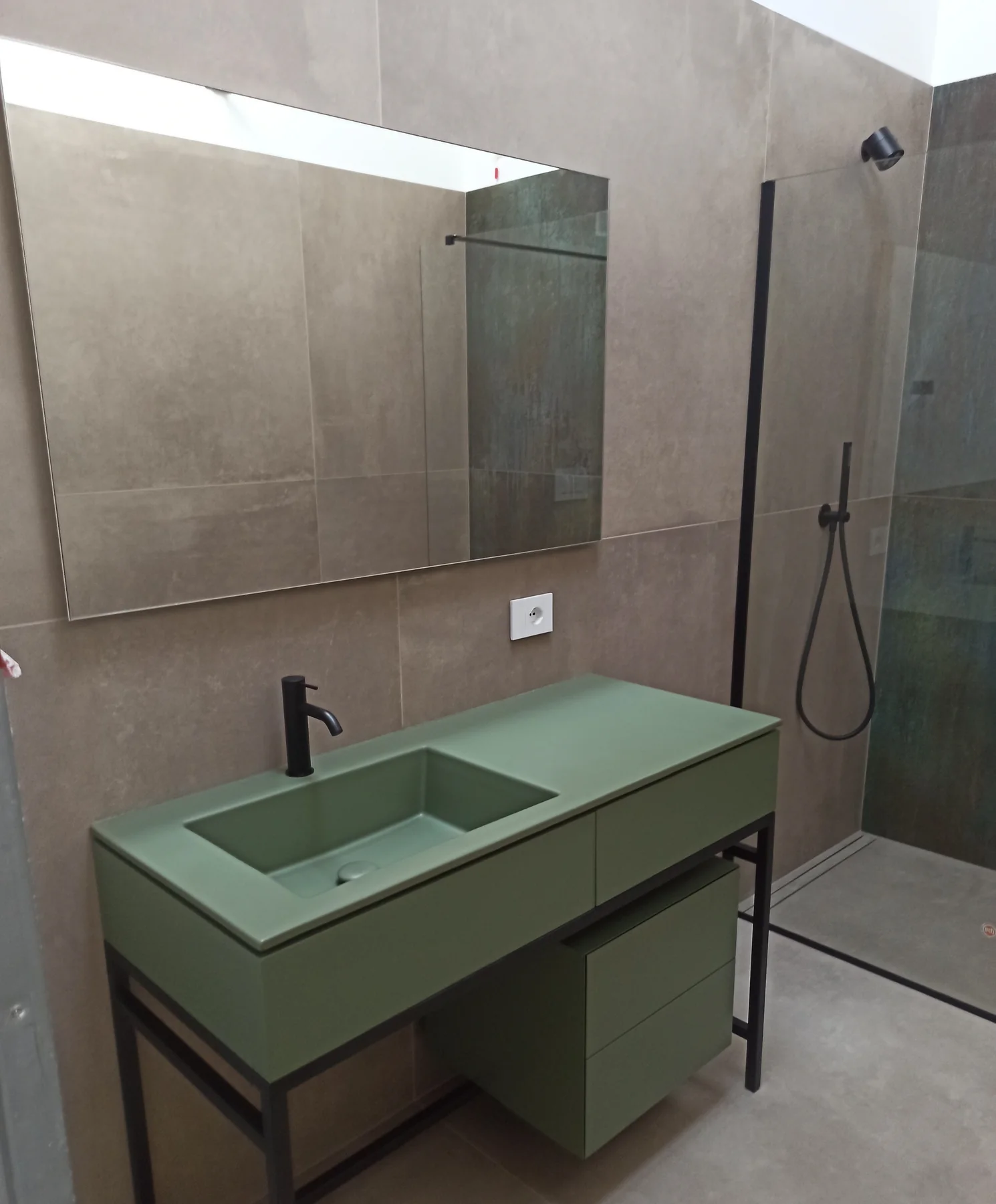 Mobile bagno verde con lavabo integrato, specchio e box doccia