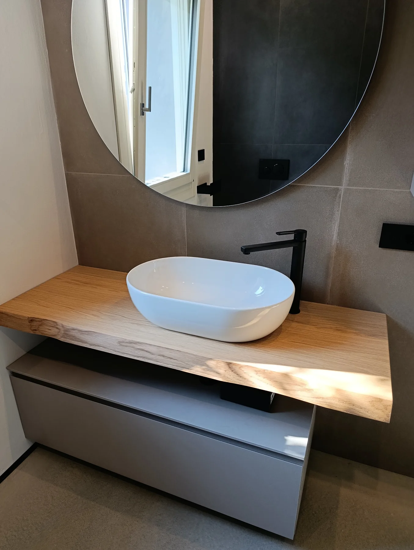 Mobile bagno con piano in legno naturale e lavabo d’appoggio